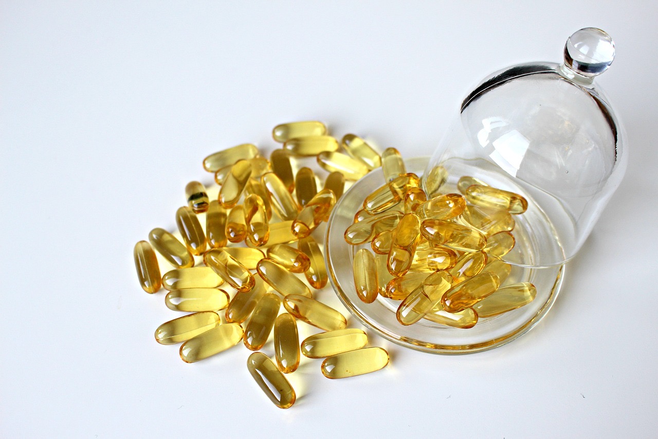 Golden omega-3 softgels in a glass dish